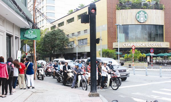 Vietnamese queue up for cups of coffee at foreign, local chains